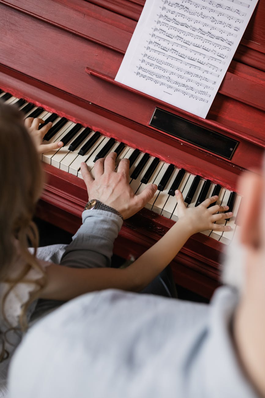 people playing piano with sheet music