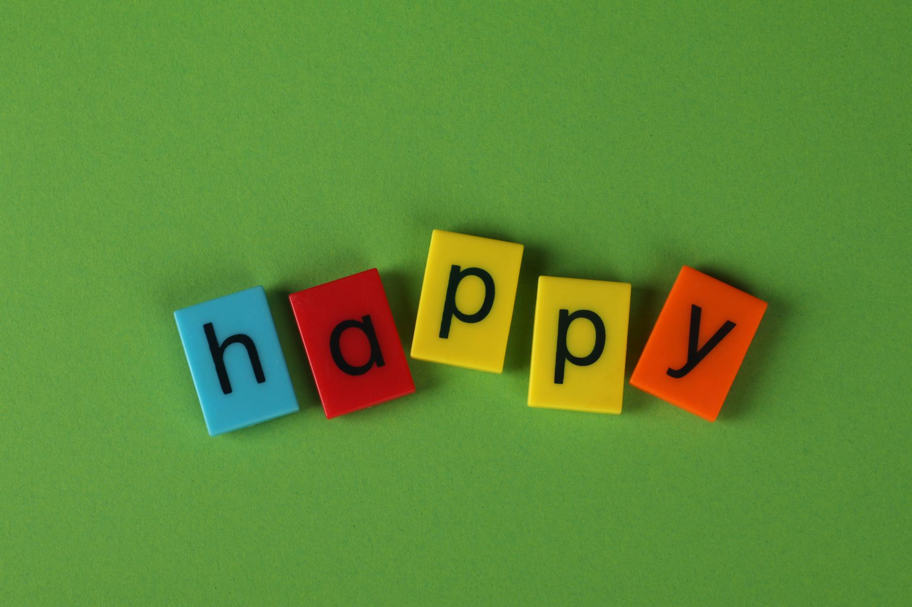 colorful letter tiles spelling happy