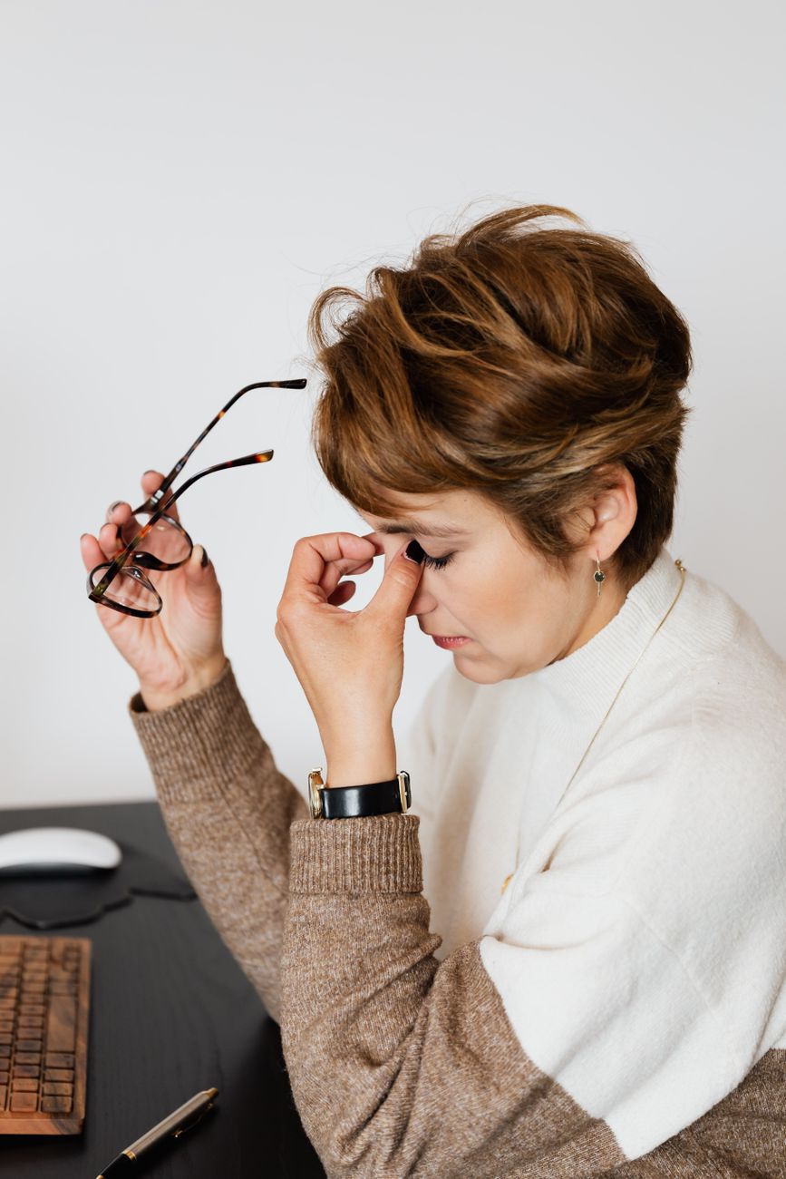 a short haired woman holding a pair of eyeglasses